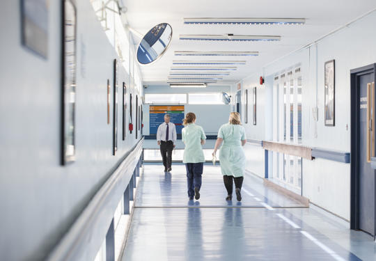Staff walking down hospital corridor