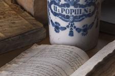 Apothecary Jar With Several Closed And One Open Handwritten Recipe Books (1)